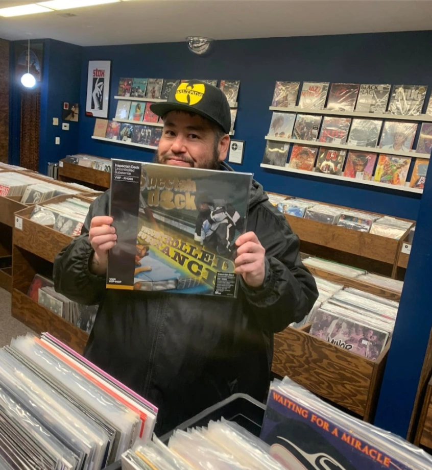 A happy customer holding a record he found at Modern Sounds
